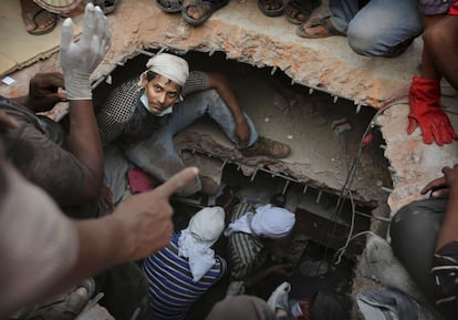 Voluntarios buscan supervivientes entre los escombros del edificio derrumbado en Dacca (Bangladesh), 25 de abril de 2013.