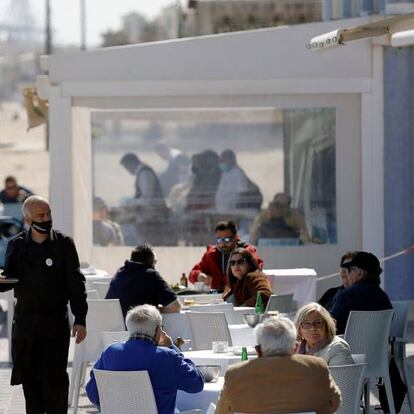 Un camarero atiende las mesas de una terraza en la playa de la Malvarrosa (Valencia), el 15 de marzo.