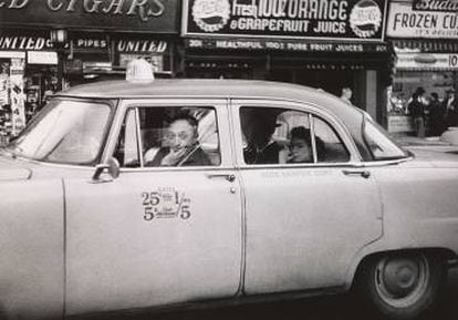 Conductor de taxi al volante con dos pasajeros, N.Y.C. 1956
