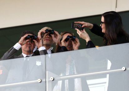 La actriz Liv Tyler toma una fotografía de sus amigos mientras estos miran por sus binoculares durante el festival de carreras de caballos de Cheltenham.