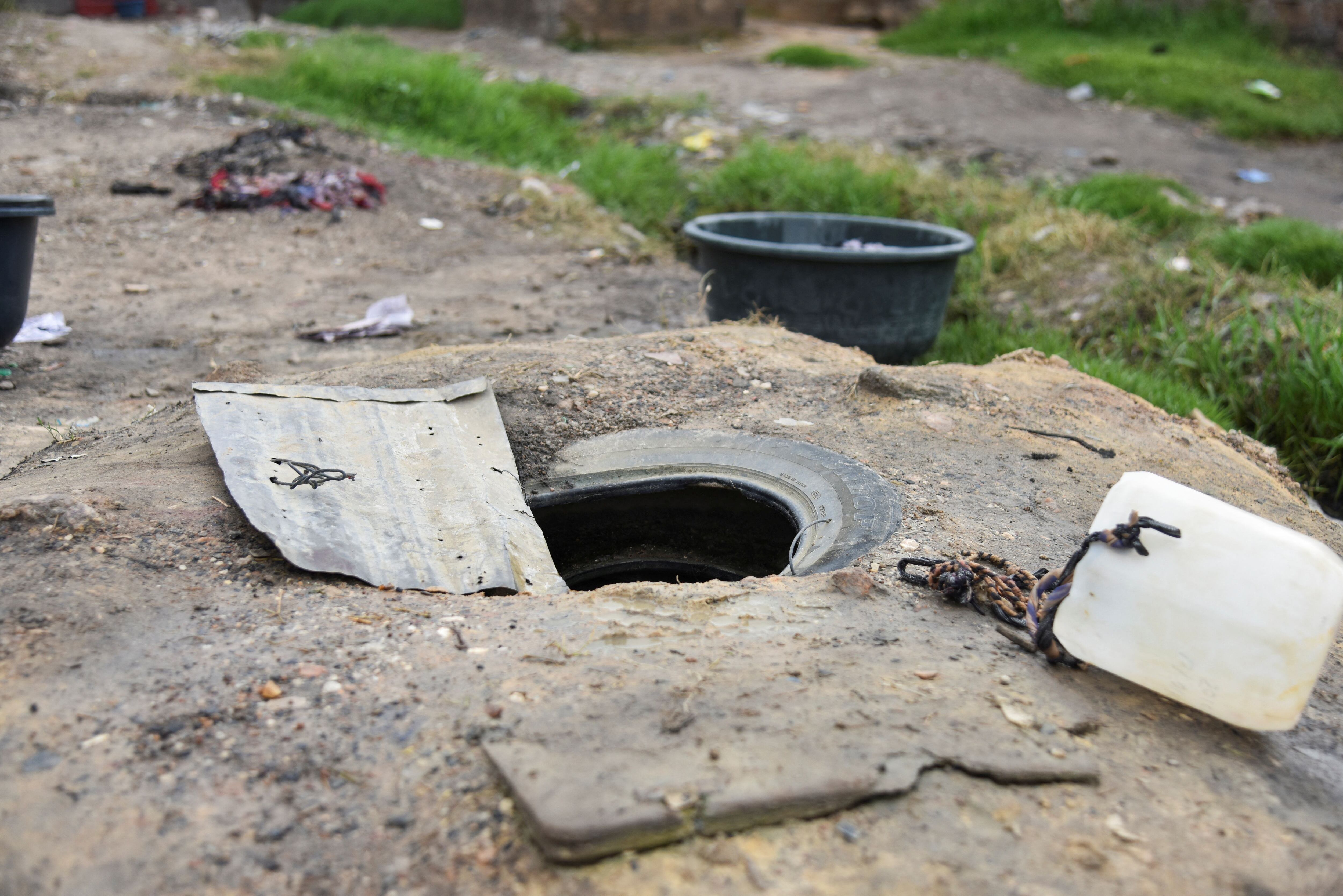 Vista de un agujero en el suelo utilizado por los residentes para sacar agua en medio de un brote mortal de cólera en Lusaka.