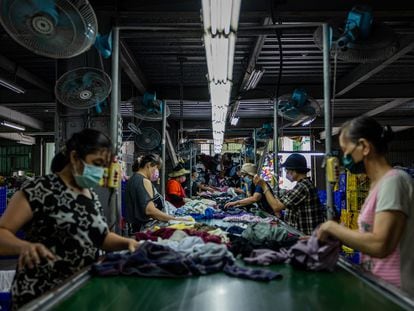 Varios trabajadores clasifican la ropa de segunda mano en una fábrica de reciclaje textil el 15 de julio de 2022 en la ciudad de New Taipei, Taiwán.