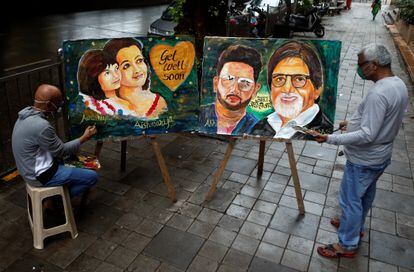 Dos artistas de Mumbai (India) pintan (a la izquierda) a Aishwarya Rai y su hija Aaradhya y (a la derecha) a Abhishek Bachchan y su padre, Amitabh, el 13 de julio, tras conocer que han dado positivo en la covid-19.