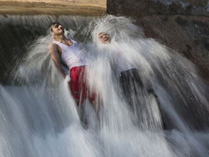 Dos hombres se bañan para combatir el calor en las afueras de Islamabad, Pakistán.