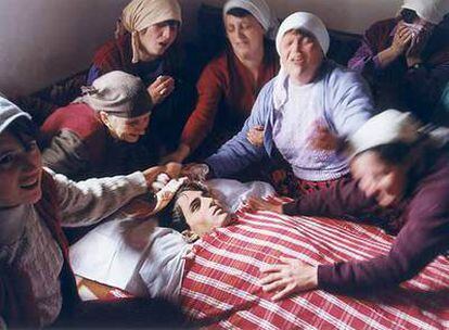 Mujeres albanokosovares lloran en Dragobil ante el cadáver de Ali Murat Pacarizi, soldado del Ejército de Liberación de Kosovo, en una foto ganadora del Premio Ortega y Gasset de 1999, expuesta en <i>Latidos de un mundo convulso.</i>