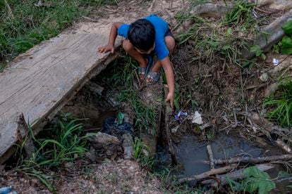 Un niño juega en el caño por el que pasan las aguas fecales de uno de los asentamientos de Tibú, la frontera colombiana con Venezuela.