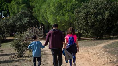 Una familia pasea por la Casa de Campo de Madrid.