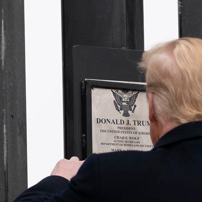 President Donald Trump looks at a plaque before signing it as he tours a section of the U.S.-Mexico border wall, Tuesday, Jan. 12, 2021, in Alamo, Texas. (AP Photo/Alex Brandon)