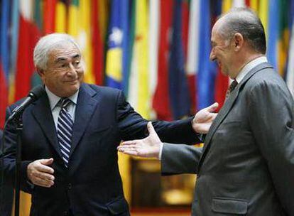 Rodrigo Rato (derecha) tiende la mano a su sucesor al frente del FMI, Dominique Strauss-Kahn, ayer en Washington.