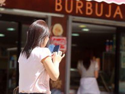 Una usuaria utiliza su smartphone en una calle de Madrid.