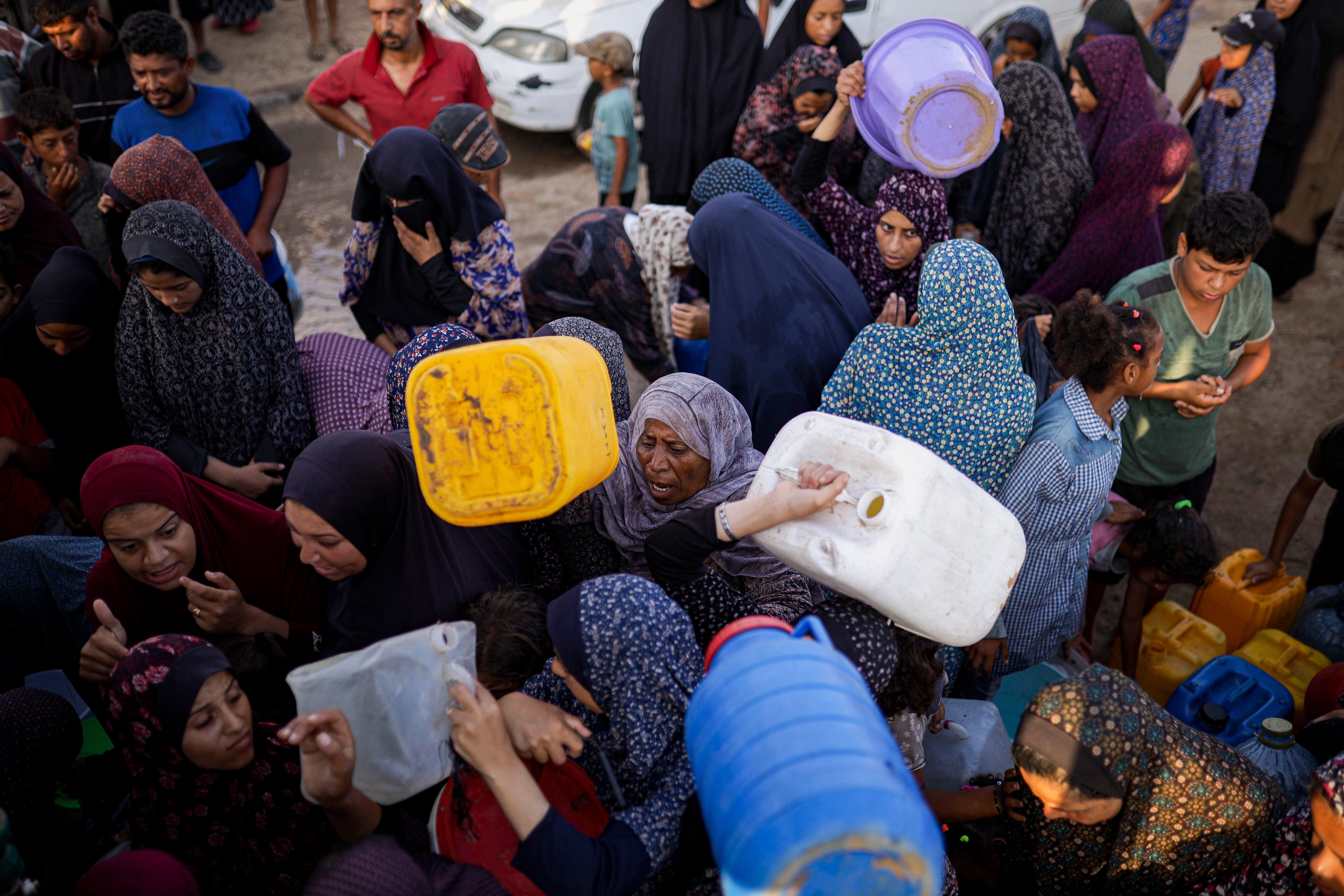 Palestinians displaced by the Israeli bombardment of the Gaza Strip queue for water at a makeshift tent camp in the southern town of Khan Younis, Monday, July 1, 2024. (AP Photo/Jehad Alshrafi)