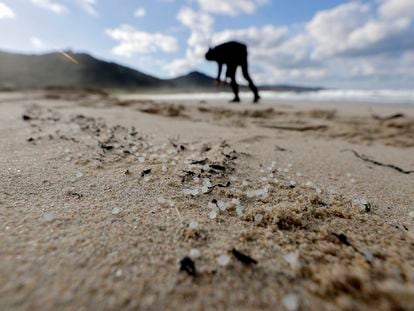 Una persona recoge 'pellets' este jueves, en la playa de Traba, situada en el 'concello' coruñés de Laxe (Galicia).