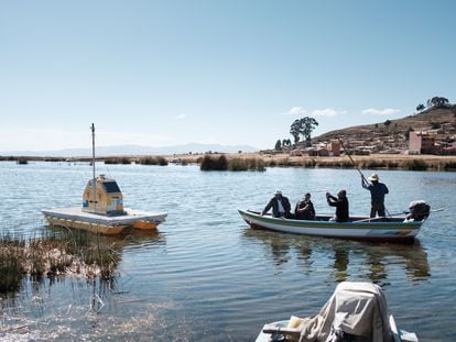 Técnicos se acercan para inspeccionar una boya hidrológica que monitorea las condiciones del lago Titicaca, en Bolivia.