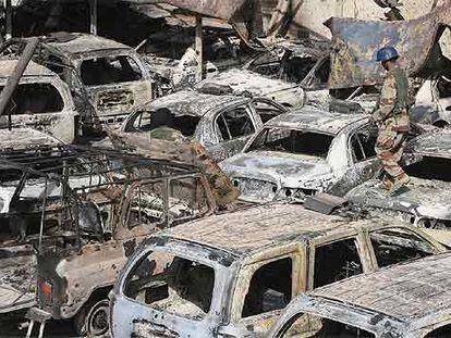 Un soldado iraquí camina sobre coches quemados durante los enfrentamientos armados del viernes en Amara.