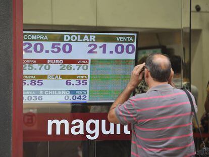 Un hombre observa una pizarra con la cotización del dólar en una casa de cambio en Buenos Aires.