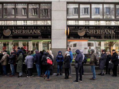Un grupo de gente haciendo cola para entrar en una sucursal del banco público ruso Sberbank.