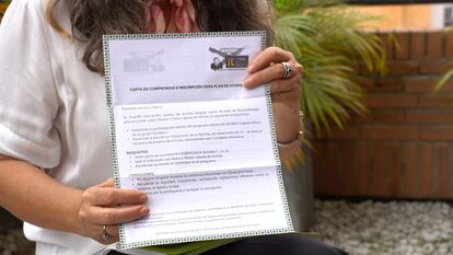 La periodista Ruby Morales sostiene en sus manos una carta de compromiso e inscripción para plan de vivienda firmada por Rodolfo Hernández.