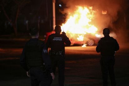 Agentes de policía frente a un auto incendiado por miembros del Cártel Jalisco Nueva Generación, en Zapopan, Estado de Jalisco (México), el 9 de agosto de 2022.