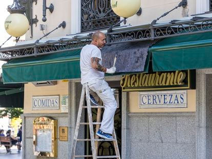 Un trabajador pinta un establecimiento en Madrid.