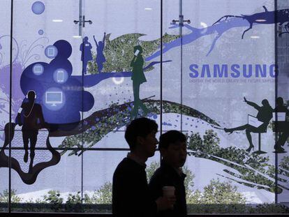 Dos personas pasean en Seúl ante una tienda de Samsung. 