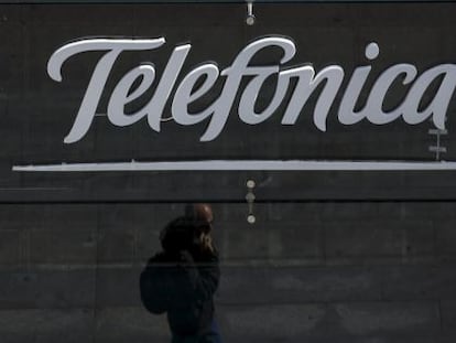 Un viandante pasa por debajo del logo de Telef&oacute;nica