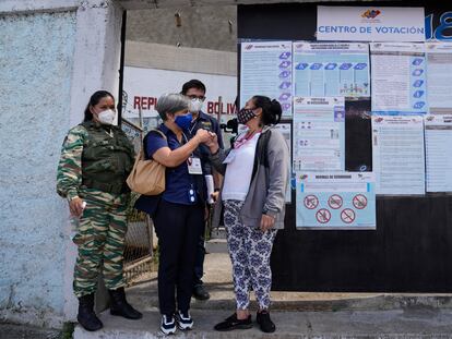 Isabel Santos, jefa de la misión de observación electoral de la Unión Europea en Venezuela saluda a una mujer en la puerta de un centro de votación.