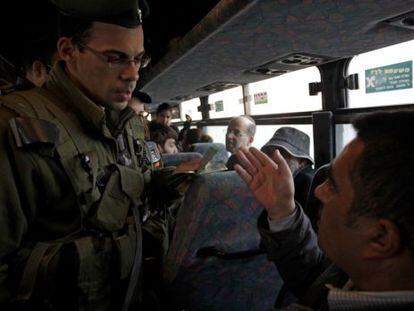 Un soldado israel&iacute; pide la documentaci&oacute;n a un palestino en un autob&uacute;s, en el puesto de control de Hizme, antes de entrar en Jerusal&eacute;n.