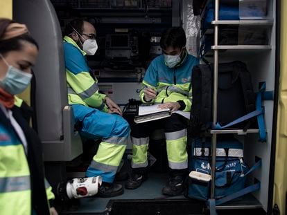 Varios trabajadores sanitarios de una UVI móvil del SUMMA 112 hacen anotaciones durante su jornada de trabajo el pasado viernes en Madrid.
