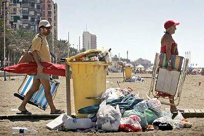 Dos turistas iban ayer a la playa de Almería, que también sufre la acumulación de basura.
