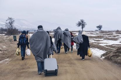 Un grupo de refugiados camina en la frontera entre Macedonia y Serbia.