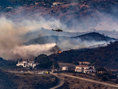 Un helicóptero participa en las labores de extinción del incendio en Mijas (Málaga), este domingo.