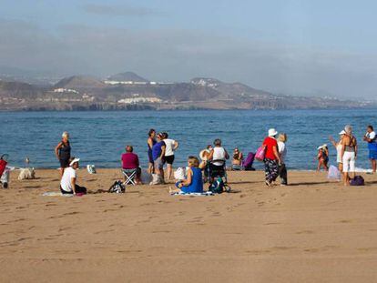 Turistas descansan en una playa.