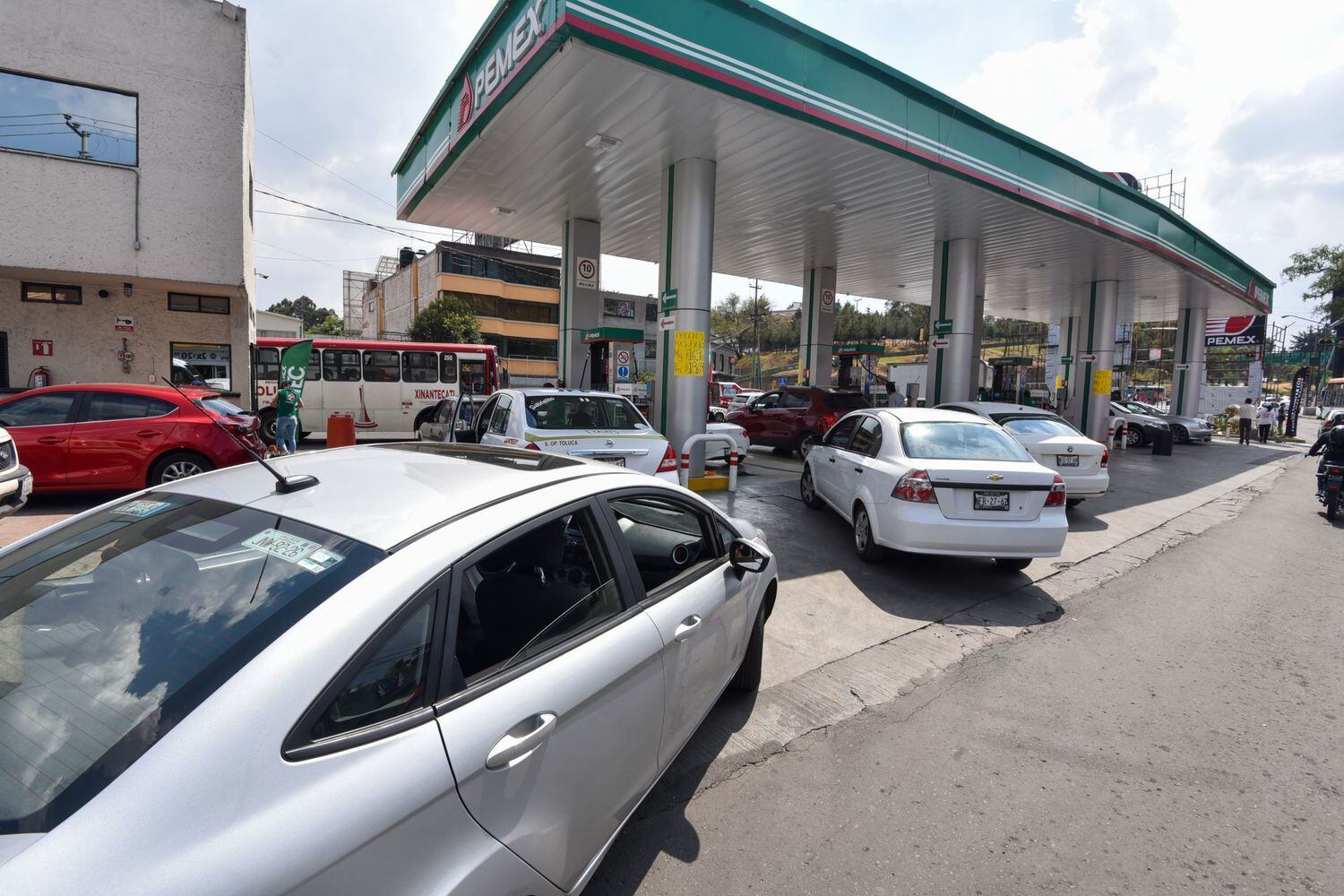 Automovilistas hacen fila para poder cargar combustible en México.