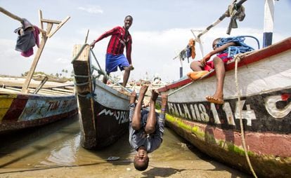 Niños ghaneses juegan junto a barcos de pesca.