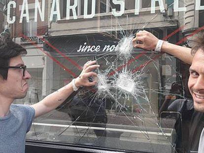 Nicolas y Grégoire, del restaurante francés Canard Street, se fotografían con el escaparate que encontraron roto el 4 de junio de 2018.