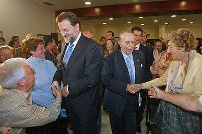 Mariano Rajoy y Manuel Fraga saludan a los asistentes a la presentación de la candidatura del PP por Pontevedra.