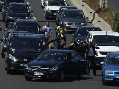 Un grup de taxistes discuteixen amb el conductor d'un vehicle amb llicència de transport de viatgers.