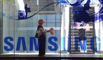 Una mujer pasa junto al logo de Samsung en la sede de la compa&ntilde;&iacute;a en Se&uacute;l.