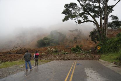 Dos personas observan una carretera bloqueada tras el derrumbe en Rosas, departamento del Cauca (Colombia) que dejó más de 900 personas afectadas