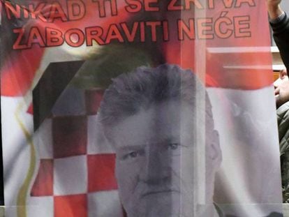 Bosniocroatas sujetan una bandera que muestra a Slobodan Praljak, en Mostar (Bosnia) este miércoles, tras el suicidio del exgeneral.