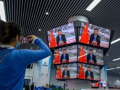 Una mujer graba el discurso de Xi Jinping durante la inauguración de una feria comercial, el pasado jueves en Shanghái.