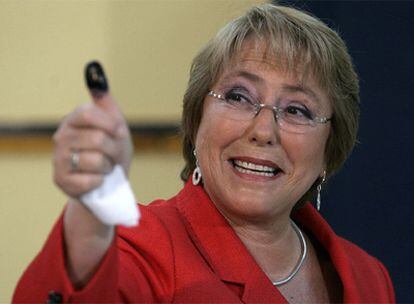 La presidenta Bachelet muestra su dedo lleno de tinta con la que se marca a los electores tras emitir su voto.