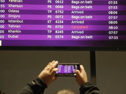 Un hombre fotografía la pantalla de una aeropuerto con varios vuelos cancelados en Ucrania.