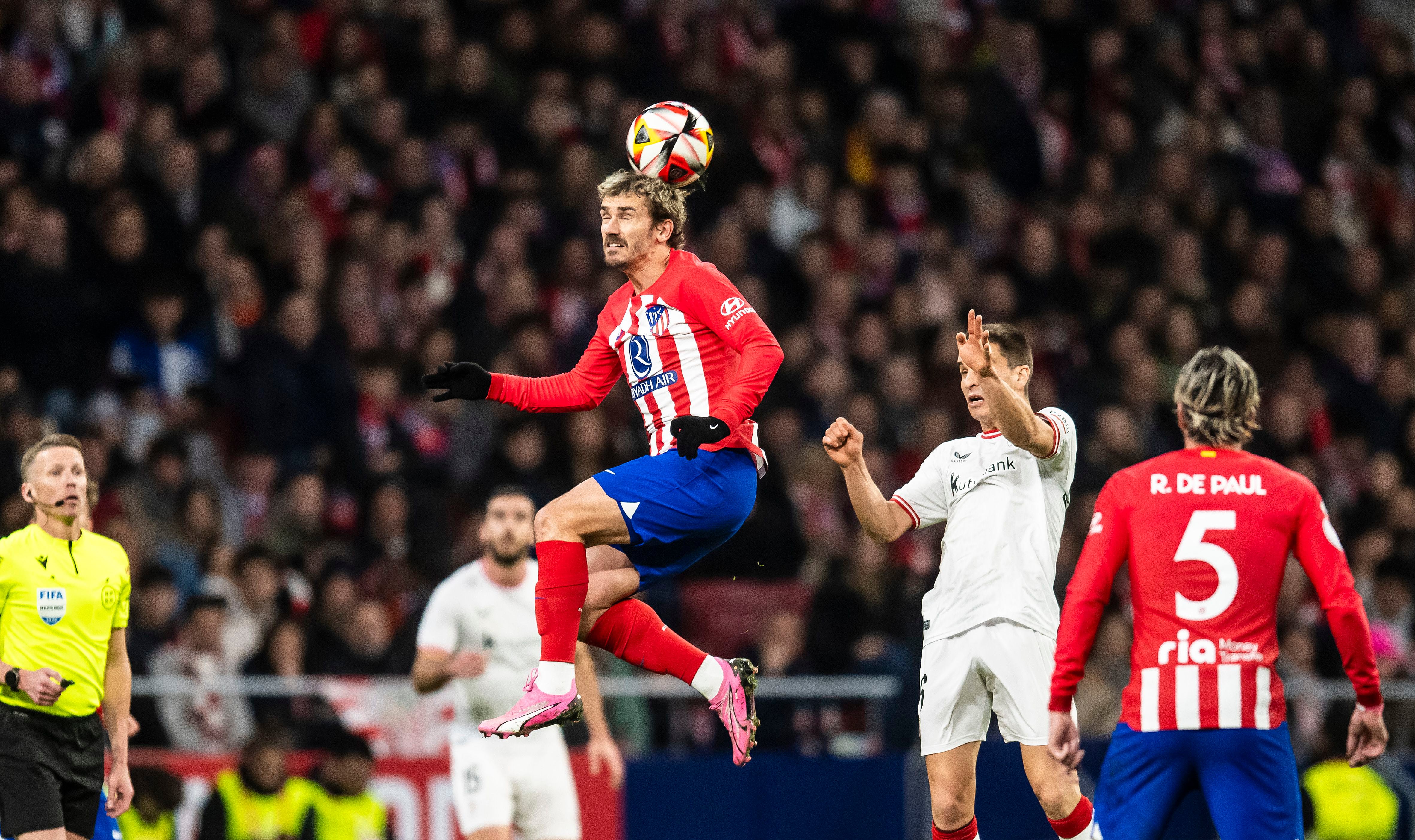 Griezmann controla el balón con la cabeza ante varios contrarios.