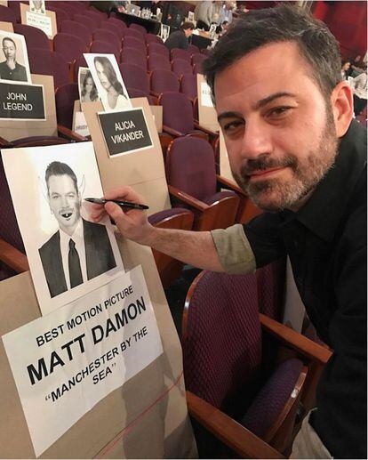 Jimmy Kimmel no tiene intención de dar tregua a Matt Damon ni el día de los Oscar. En la imagen, pintándole bigote y orejas de demonio al cartel que señala el asiento del actor en el teatro.