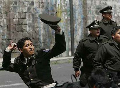 Un policía tira una piedra contra varios estudiantes que protestaban ayer cerca del Congreso ecuatoriano, en Quito.