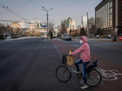 Una mujer se desplaza en bicicleta por Pekín.