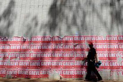 Un hombre camina frente a varios carteles donde se lee la frase "funcionarios en huelga", en la Esplanada dos Ministerios en Brasilia (Brasil), donde los servidores públicos federales reclamaron por el reajuste del piso salarial y la reestructuración de la carrera.