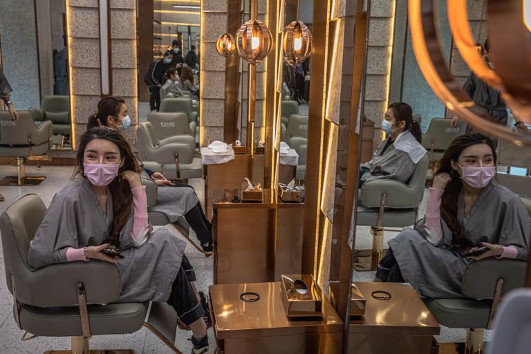 Dos mujeres con máscaras en un salón de belleza de Wuhan (China), este martes.