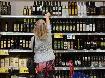 Una clienta de un supermercado español elige una botella de aceite de oliva.